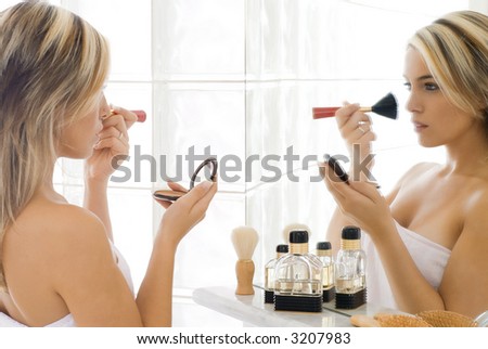 portrait of beautiful blond woman doing daily morning routines in front of the mirror