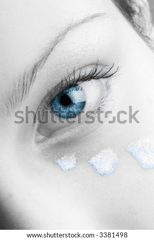 a sweet black and white image of a girl with petals of rose painted on her face and colored eyes