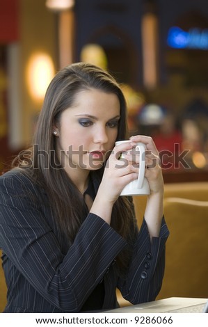 young woman looking sad warming herself with e hot cup of tea