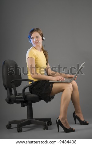 secretary with computer on legs looking angry against somebody