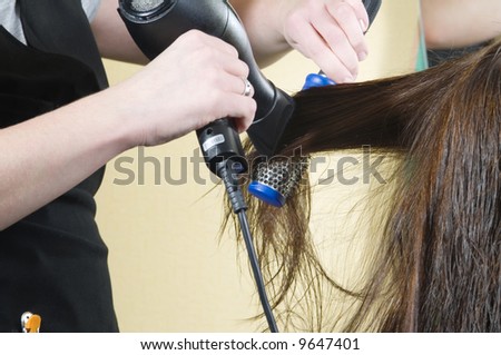 close up of girl head in beauty salon while an hair stylist brush and dry her hair