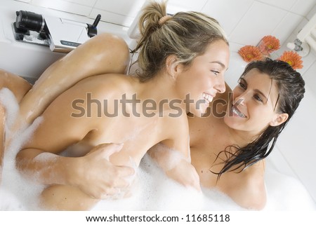 two young nice girls into a bath foam chatting and smiling