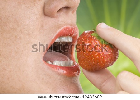 a red open mouth eating a strawberry fruit