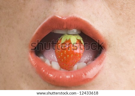 close up of a mouth with red lips biting a little strawberry