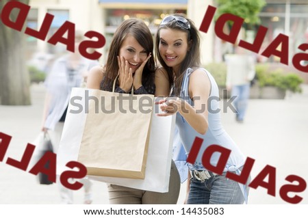 two girls looking at a shop window with a lot of interest