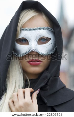 pretty blond hidding her face with white mask and black hood