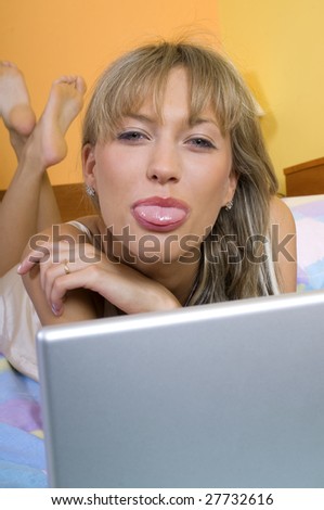 pretty young woman laying down making face and showing her tongue