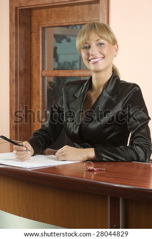 blond girl Hotel reception in black suit smiling