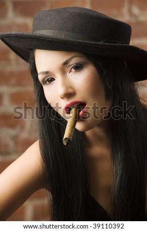 stock photo very cute asian girl with a black hat smoking a cigar
