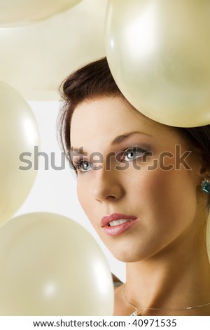 close up portrait of a young pretty brunette with air balloons around her face