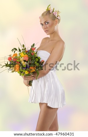 young and beautiful woman in short white dress with flowers in hair and keeping a color bouquet