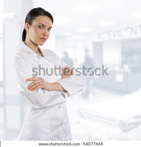 cute brunette woman in white gown as a medical doctor looking in camera