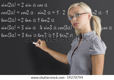 stock photo : pretty young teacher with blond hair and glasses taking a math 
