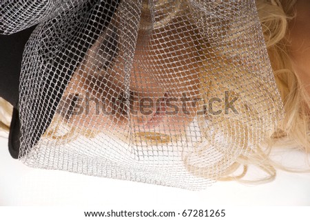 creative portrait of blond beautiful girl with curly hair style black hat and a silver net over her face