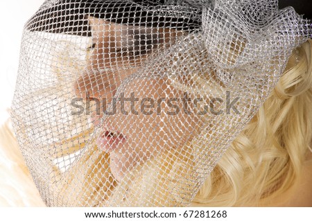 creative portrait of blond beautiful girl with hair style black hat and a silver net over her face