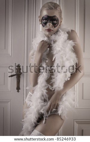 pretty blonde girl wearing a feather boa and panties posing in a doorway