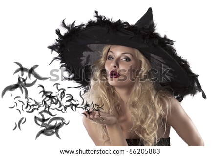 face shot of a cute and sexy girl dressed with a huge witch hat with feathers blowing a kiss