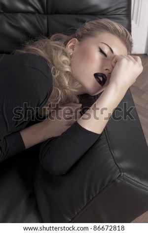 beautiful sleeping beauty laying on a black leather couch
