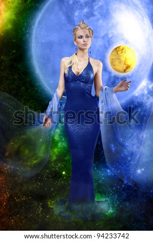 attractive stunning woman with a long blue elegant leather dress and a  stole playing with golden planet on space background