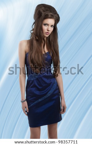fashion shot of a beauty girl with creative hairstyle wearing a blue elegant dress