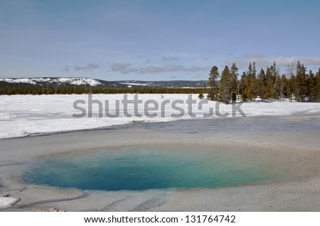 A beautiful turquoise colored pool in the thermal area of Yellowstone National Park in winter.