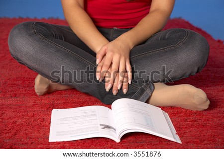 A young woman on the floor surrounded by books and a computer