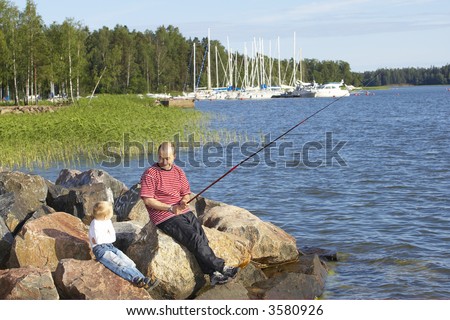 Father and son fishing with son holding worm