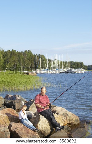 Father and son fishing with son holding worm