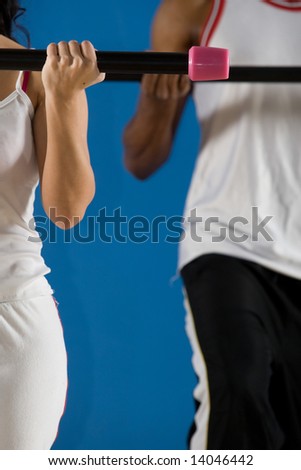 Young couple, attractive female, handsome male doing fitness exercises in the gym