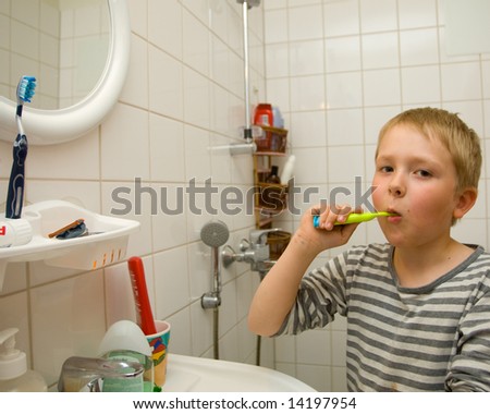 An isolated picture of a young boy cleaning his teeth