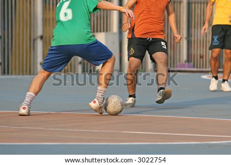Player make a tackle in a game of street football (soccer)