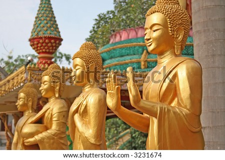 3 golden Buddhist statues with a narrow depth of field