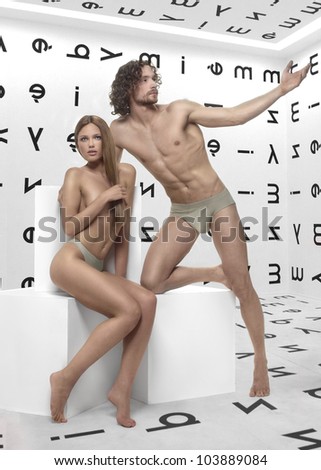 beautiful man and woman Adam and Eve, posing on a white background with white cubes