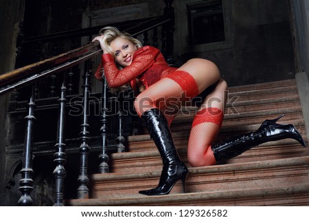 blonde in the red stockings on the stairs of the ancient house