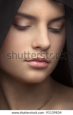 portrait of a beautiful young woman with a black veil on her head