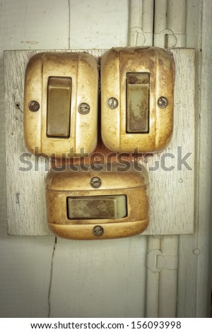Old dirty electrical switch on wooden wall