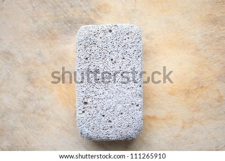 Raw pumice stone on wooden surface, light weight and with rough surface.