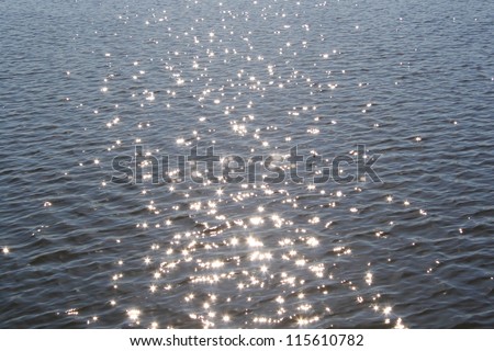 Blue lake water surface with sparks