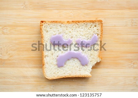 Sad and unhappy face made from toasted bread with