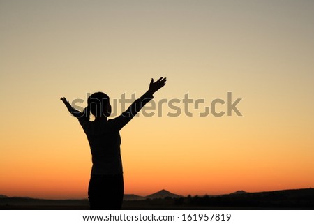Young woman in sunset silhouette