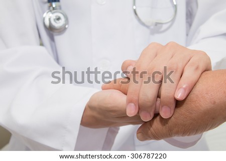 Doctor holding an old woman\'s hand