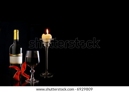 Red wine composition with wineglass, wine bottle , candle and red loop