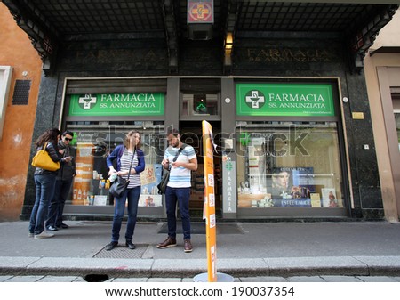 BOLOGNA, ITALY - APRIL 19, 2014: Pedestrians walk past a pharmacy in Bologna, Italy, on Saturday, April 19, 2014.