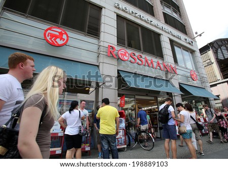 BERLIN, GERMANY - JUNE 11, 2014: Pedestrians walk past a Rossmann drugstore in  Berlin, Germany, on Saturday, June 11, 2014.  Dirk Rossmann GmbH is Germany's third largest drugstore chain.