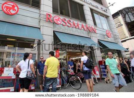 BERLIN, GERMANY - JUNE 11, 2014: Pedestrians walk past a Rossmann drugstore in  Berlin, Germany, on Saturday, June 11, 2014.  Dirk Rossmann GmbH is Germany\'s third largest drugstore chain.