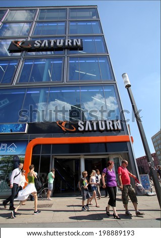 BERLIN, GERMANY - JUNE 11, 2014: Pedestrians walk past a Saturn consumer electronics store in  Berlin, Germany, on Saturday, June 11, 2014. Media-Saturn-Holding GmbH is a German corporate group.