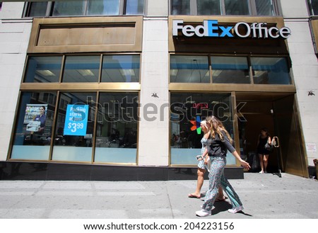 NEW YORK CITY - FRIDAY, JUNE 20, 2014:   Pedestrians walk past a FedEx Office store in New York City on Friday, June 20, 2014.