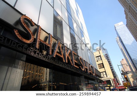 NEW YORK CITY - FEB. 25, 2015:  Pedestrians walk past a Shake Shack restaurant. Shake Shack is a fast casual restaurant chain based in New York City