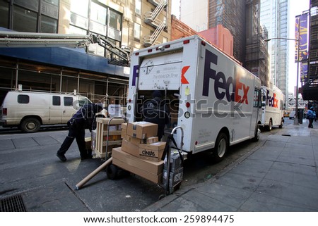 NEW YORK CITY - FEB. 25, 2015:  FedEx drivers unload two delivery vans in midtown Manhattan. FedEx Corporation is an American global courier delivery services company