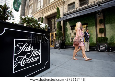 NEW YORK CITY - FRIDAY, MAY 8, 2015: Pedestrians walk past Saks Fifth Avenue in Manhattan. Saks Fifth Avenue is an American department store chain owned by the Hudson\'s Bay Company.